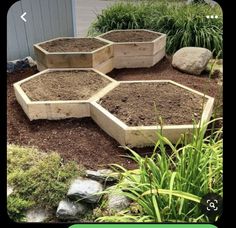 several wooden hexagonal planters sitting in the middle of some dirt and grass