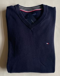 Classic Style, Soft Comfortable Fit! You are bidding on a 100% Authentic Mens Tommy Hilfiger Logo V-Neck Sweater (MSRP $59.50). This sweater is Brand NEW with tags. Size:  Small Color:  Navy Ribbed v-neck Tommy Hilfiger logo embroidered on left chest Long sleeve with rib-knit cuffs Ribbed  hem 100% cotton Imported Please email me with any questions prior to bidding.   FREE US SHIPPING!  I ship next business day after payment is received. ****International bidders: You are responsible for any cus Tommy Hilfiger V-neck Winter Top, Classic Navy V-neck Sweater, Tommy Hilfiger Menswear, Tommy Hilfiger Logo, Tommy Hilfiger Man, Knit Cuff, Cotton Sweater, Logo Embroidered, Long Sleeve Pullover