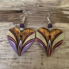 two heart shaped wooden earrings with purple beads