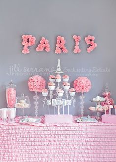 the dessert table is decorated with pink carnations and paris themed cupcakes