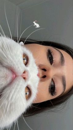 a woman with long black hair and white cat's paw on her head looking at the camera