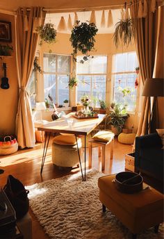 a living room filled with lots of furniture and plants on the window sills