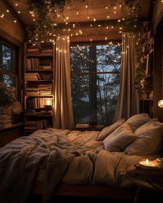 an unmade bed with lights strung from the ceiling and bookshelves above it