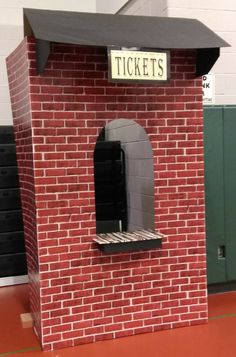 a fake brick building with a ticket booth on top