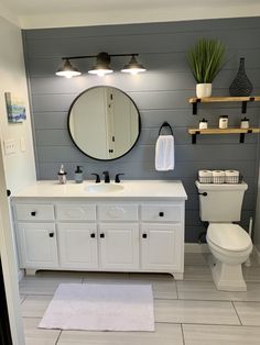 a bathroom with a toilet, sink, and mirror in the middle of the room