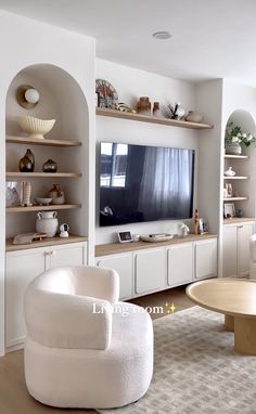 a living room filled with furniture and a flat screen tv on top of a wall