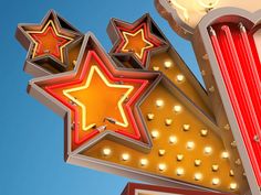 a close up of a neon sign with stars on it's sides and lights