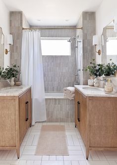 a bathroom with white tile and wood cabinets