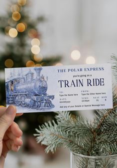 the polar express train ride ticket is being held up by someone's hand next to a christmas tree