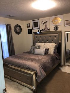 a bedroom with a bed, mirror and pictures on the wall