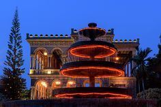 a lit up fountain in front of a building