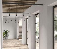 an empty room with wooden beams and hanging plants in the corner, along with brick flooring