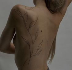 the back of a woman's body with leaves drawn on her upper and lower back