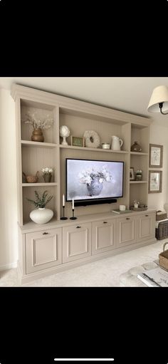 a living room with a large tv on the wall