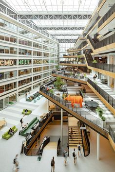 people walking around an indoor shopping mall with multiple levels and balconies on the second floor