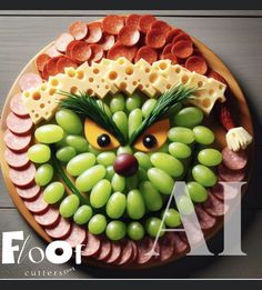 a plate that has grapes, ham and cheese on it with an animal face made out of them