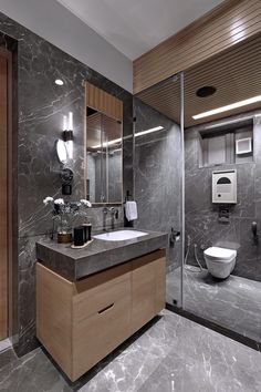 a modern bathroom with marble counter tops and wood accents, along with a walk in shower