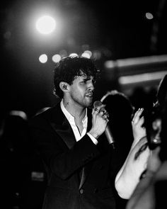 black and white photograph of a man in a suit talking on his cell phone at an event