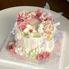 a cake decorated with flowers and butterflies on a plate