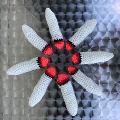 a group of white and red crocheted objects on top of each other in the shape of a star