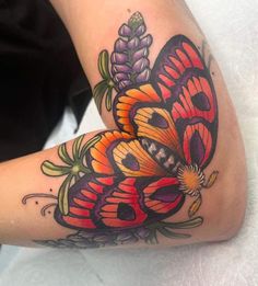 a colorful butterfly tattoo on the arm