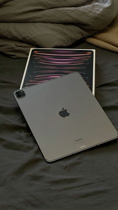 an apple laptop computer sitting on top of a bed