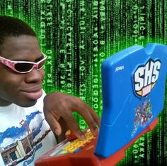 a young man wearing sunglasses playing with a toy computer in front of a green background