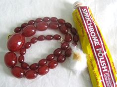 two red beads and a tube of toothpaste on a white surface next to it