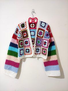 a colorful crocheted jacket hanging on a hook