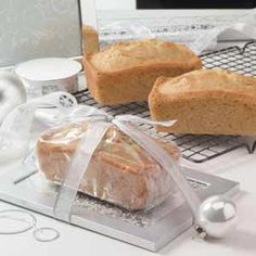 two loaves of bread sitting on top of a cooling rack next to a computer