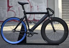 a black and blue bike parked next to a building