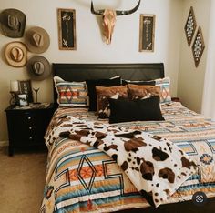 a bed room with a neatly made bed and cow head on the wall above it