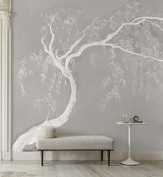 a white tree painted on the wall next to a bench