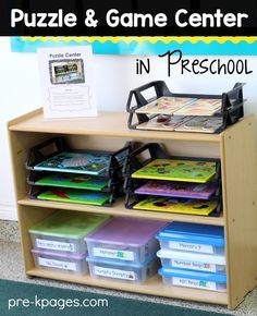 a wooden bookcase filled with children's books next to a sign that says puzzle and game center in preschool