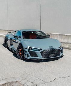 a blue sports car parked in front of a building on the side of the road