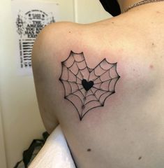 a spider web tattoo on the back of a woman's upper arm and shoulder