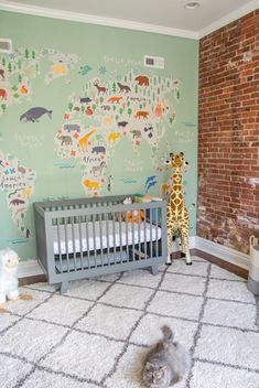 a baby's room with a giraffe wallpaper and a grey crib