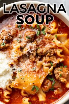 a white bowl filled with lasagna soup topped with cheese and meat, garnished with parsley