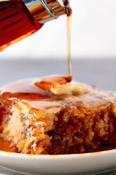 a piece of cake with caramel sauce being drizzled over it on a plate