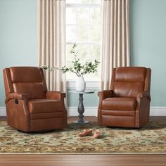 two brown recliners sitting next to each other on top of a rug in front of a window