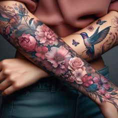 a woman's arm covered in tattoos with flowers and hummings on the arm