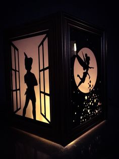 the silhouettes of peter rabbit and tinkerbell are projected into an illuminated lantern