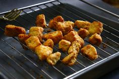 chicken nuggets on a grill with a fork sticking out of the top one