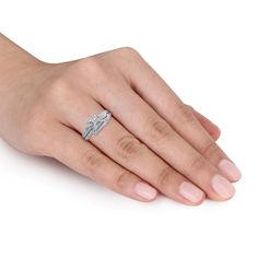 a woman's hand with a diamond ring on her left hand, wearing a white gold band