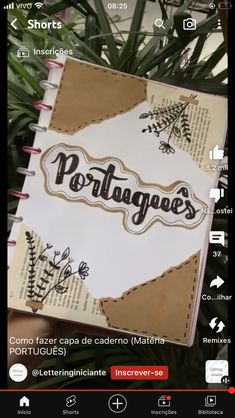 an open notebook with the word portugal written on it and some plants in the background