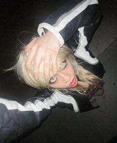 a woman with blonde hair wearing a black and white jacket