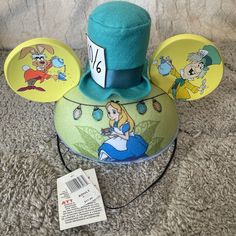 Add A Touch Of Whimsy To Your Disney Parks Ensemble With This Green Alice In Wonderland Mad Hatter Tea Party Ear Hat. Featuring Multicolored Graphics, This Unisex Hat Is Suitable For Adult Sizes 55cm And Above. Perfect For Any Disney Fan, This Hat Is A Great Addition To Your Collection Of Disneyana. Whether You're A Fan Of The Beloved Character Or Simply Love The Iconic Design, This Hat Is Sure To Make A Statement. Mickey Ear Hat, Alice In Wonderland Mad Hatter, Wonderland Mad Hatter, Ear Hat, Mad Hatter Tea, Mad Hatter Tea Party, Disney Fan, Ear Hats, Iconic Design