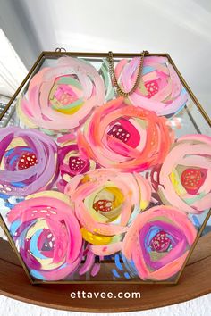 a glass box filled with colorful flowers on top of a table