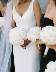 the bride is holding her bouquet and looking at another woman in front of her on her wedding day