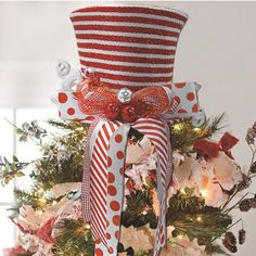 a christmas tree decorated with red and white striped ribbon, bow, and candy canes